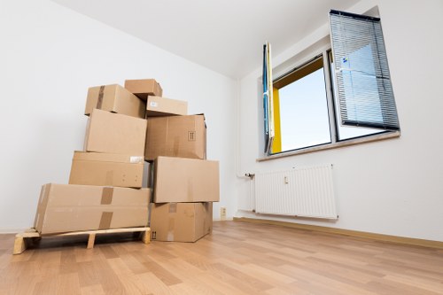 Unpacking boxes into a tidy kitchen after a move in North Finchley